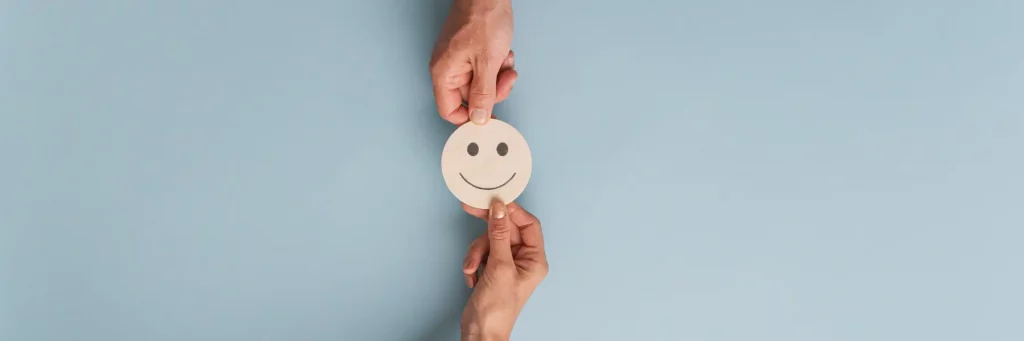 Phot d'un emoji souriant qui passe de main en main